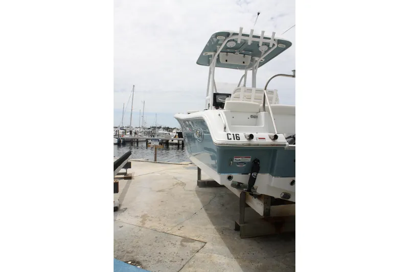 Slide: The Image of 2022 Sea Hunt Ultra 219 boat docked at a marina, showcasing its sleek design. - 6