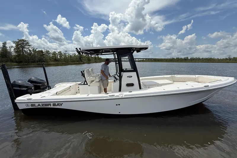 Slide: The Image of 2026 Blazer Bay Makaira 2800 boat on calm water under a partly cloudy sky. - 2