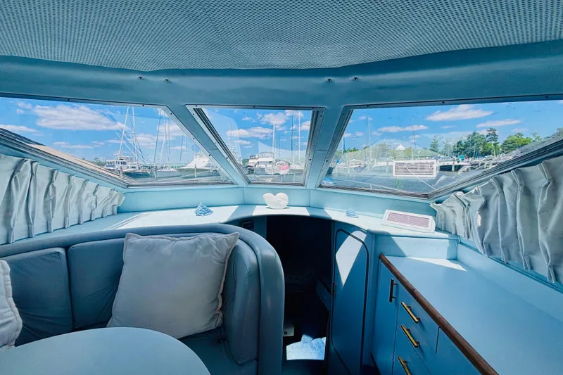 Slide: The Image of Interior of 1988 Sea Ray 305 Sedan Bridge with marina view through windows. - 11