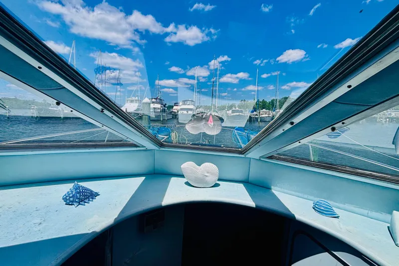 Slide: The Image of Interior view from a 1988 Sea Ray 305 Sedan Bridge, overlooking a marina under a blue sky. - 12