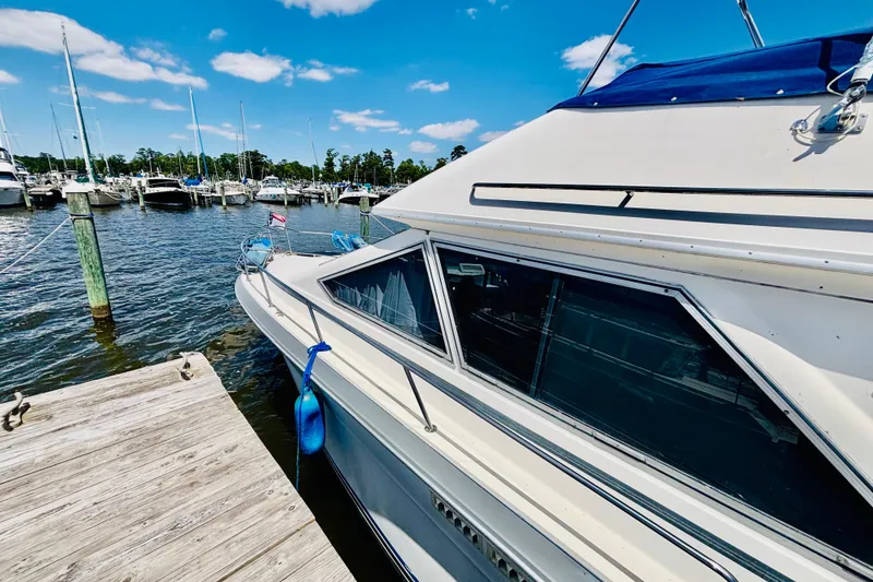 Slide: The Image of 1988 Sea Ray 305 Sedan Bridge docked at marina under clear blue sky. - 2