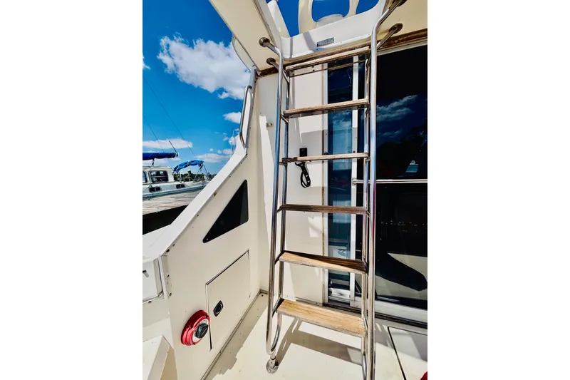 Slide: The Image of Ladder on 1988 Sea Ray 305 Sedan Bridge yacht under clear blue sky. - 6