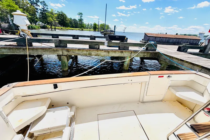Slide: The Image of 1988 Sea Ray 305 Sedan Bridge docked by a wooden pier on a sunny day. - 7