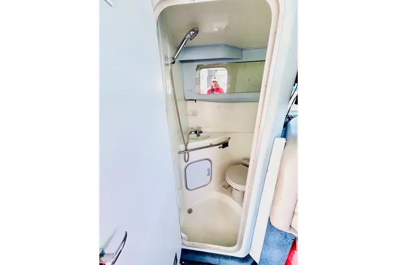Slide: The Image of 1988 Sea Ray 305 Sedan Bridge bathroom with shower, sink, and toilet. - 9