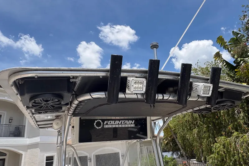 Slide: The Image of 2001 Fountain 31 Center Console boat with T-top and rod holders under a clear blue sky. - 10