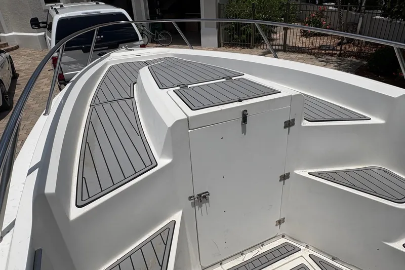 Slide: The Image of 2001 Fountain 31 Center Console boat deck with gray non-slip surface and storage compartment. - 12