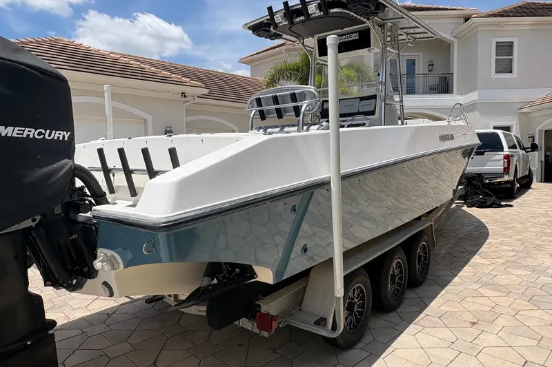 Slide: The Image of 2001 Fountain 31 Center Console boat on trailer in driveway, with Mercury engine. - 2