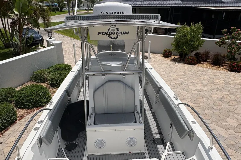 Slide: The Image of 2001 Fountain 31 Center Console boat with T-top, parked in a landscaped driveway. - 9