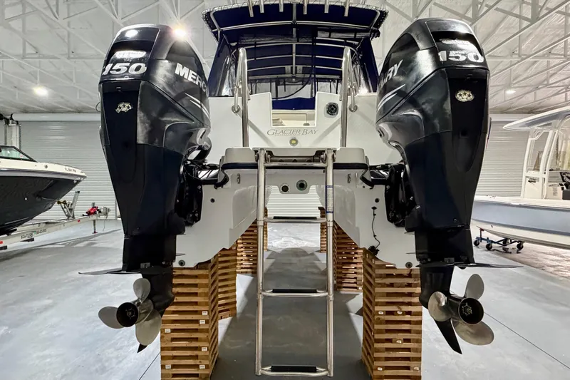 Slide: The Image of 2006 Glacier Bay 2640SX Renegade boat with twin Mercury 150 engines in a storage facility. - 10