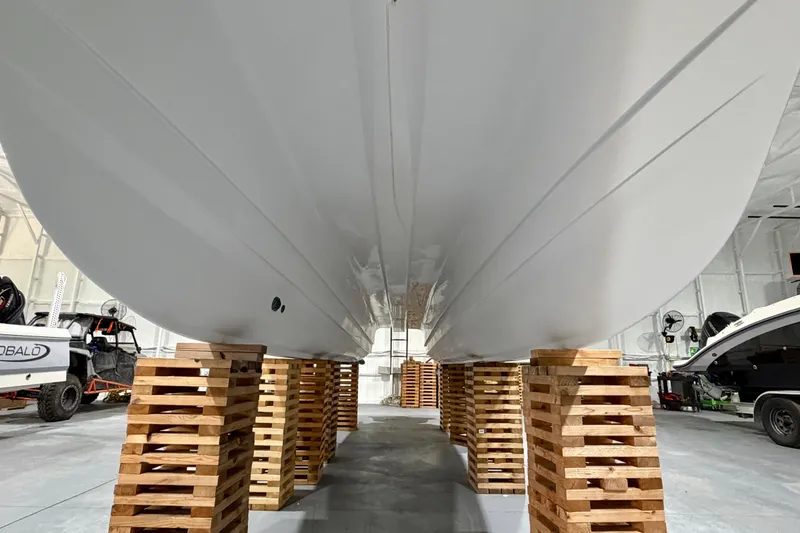 Slide: The Image of 2006 Glacier Bay 2640SX Renegade boat hull on wooden supports in a storage facility. - 18