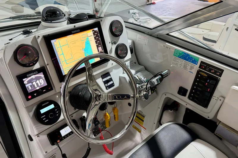 Slide: The Image of 2006 Glacier Bay 2640SX Renegade boat dashboard with navigation equipment and steering wheel. - 22
