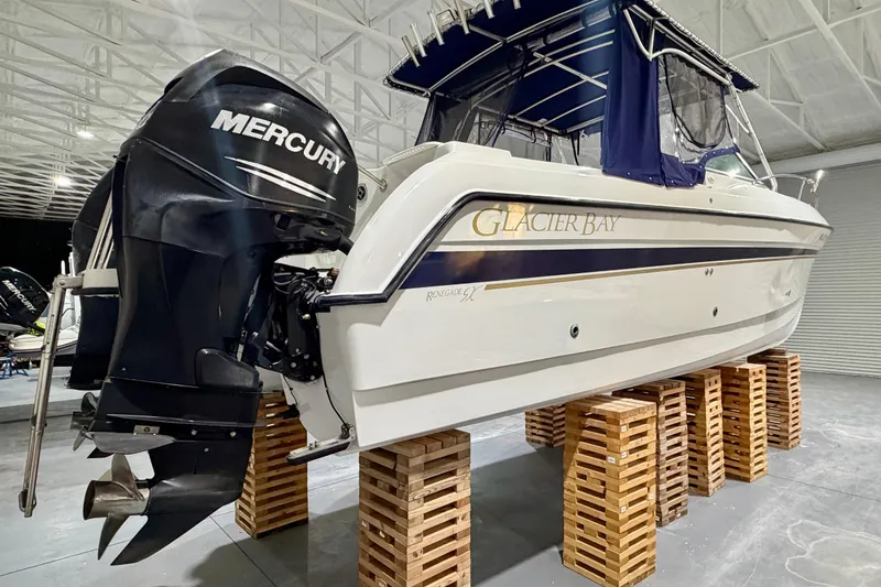 Slide: The Image of 2006 Glacier Bay 2640SX Renegade boat with Mercury engine on wooden blocks in a warehouse. - 3