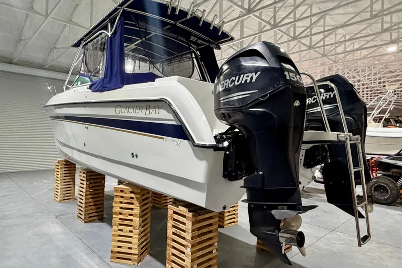 Slide: The Image of 2006 Glacier Bay 2640SX Renegade boat with dual Mercury 150 engines in a storage facility. - 4
