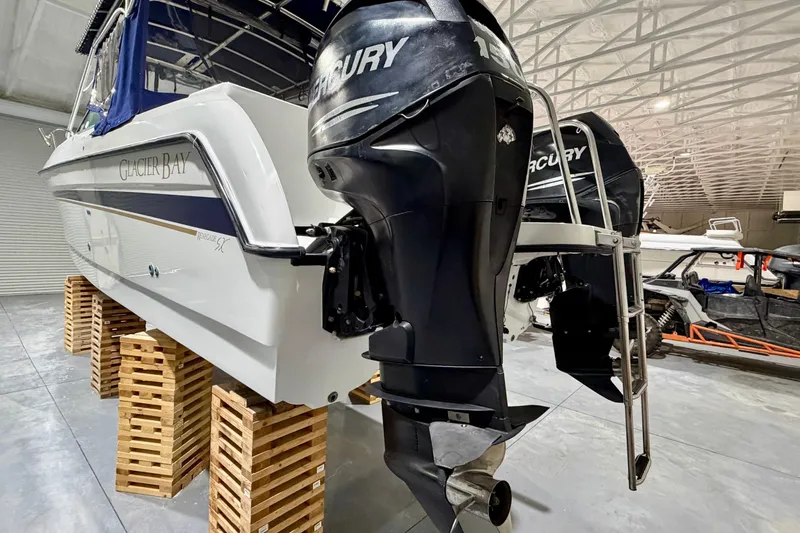 Slide: The Image of 2006 Glacier Bay 2640SX Renegade boat with dual Mercury outboard engines in a storage facility. - 7