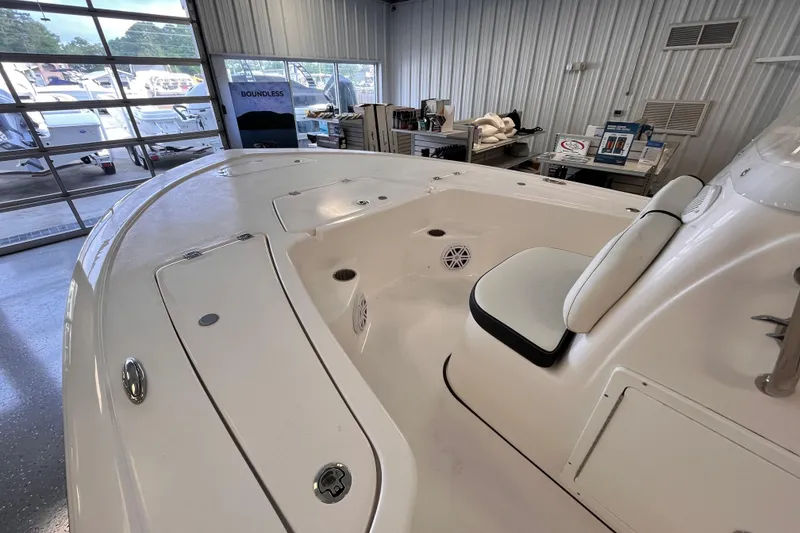 Slide: The Image of 2026 Tidewater 1910 Bay Max boat interior in showroom, featuring seating and storage. - 7