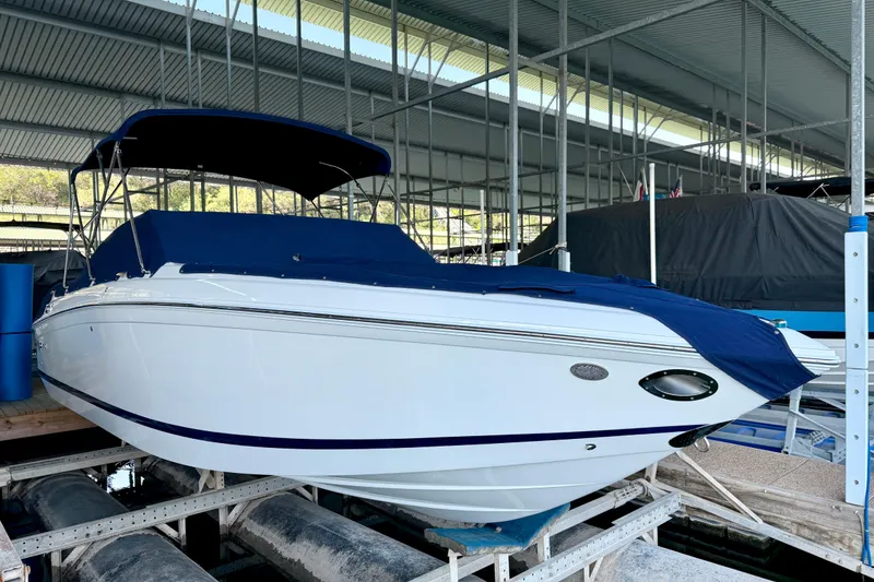 Slide: The Image of 2013 Cobalt 262 boat with blue cover docked in a marina. - 13