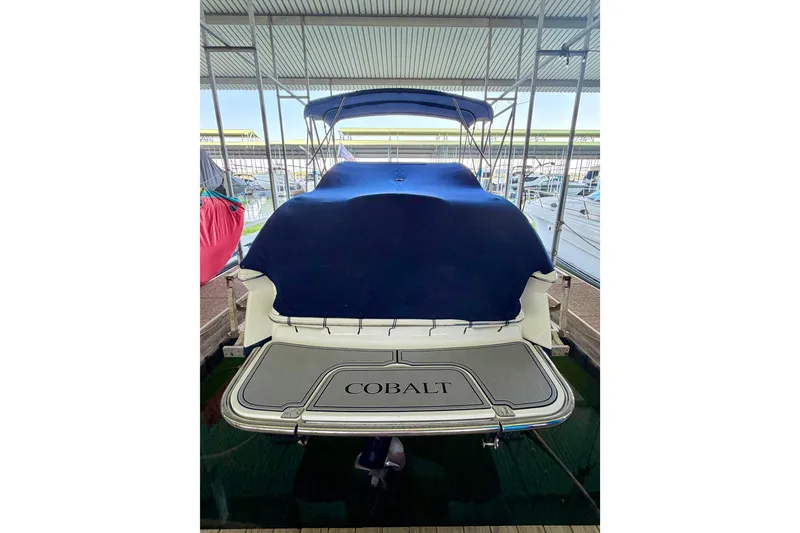 Slide: The Image of 2013 Cobalt 262 boat with blue cover docked in marina. - 15