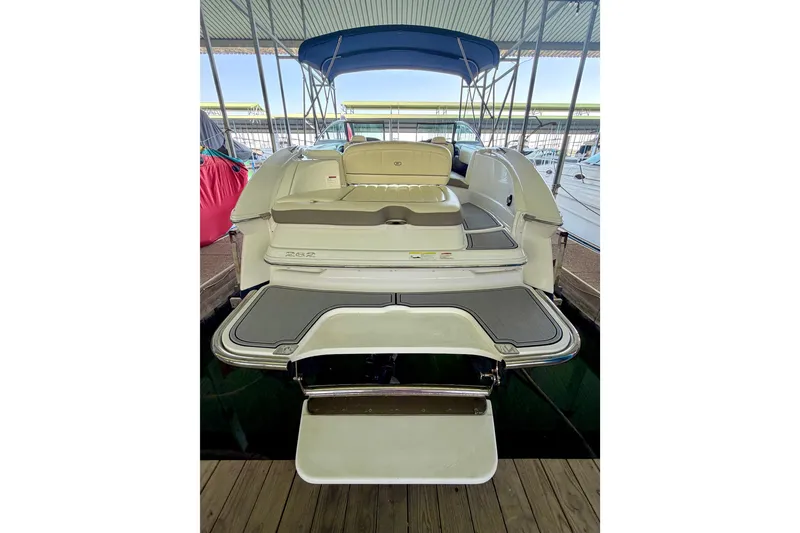 Slide: The Image of 2013 Cobalt 262 boat with swim platform and seating, docked under a canopy. - 16