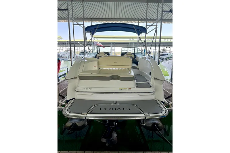 Slide: The Image of 2013 Cobalt 262 boat with seating, docked under a canopy. - 17