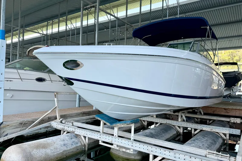 Slide: The Image of 2013 Cobalt 262 boat in a covered marina, showcasing sleek design and white hull. - 19