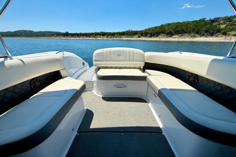 Slide: The Image of 2013 Cobalt 262 boat interior with white seating, on a scenic lake. - 26