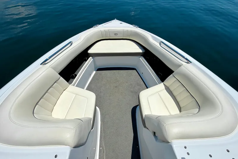 Slide: The Image of 2013 Cobalt 262 boat interior with white seating and gray carpet on calm water. - 33