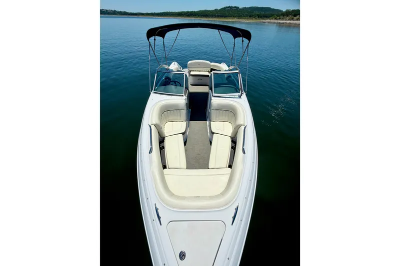 Slide: The Image of 2013 Cobalt 262 boat with white seating, on calm water, under a clear sky. - 34