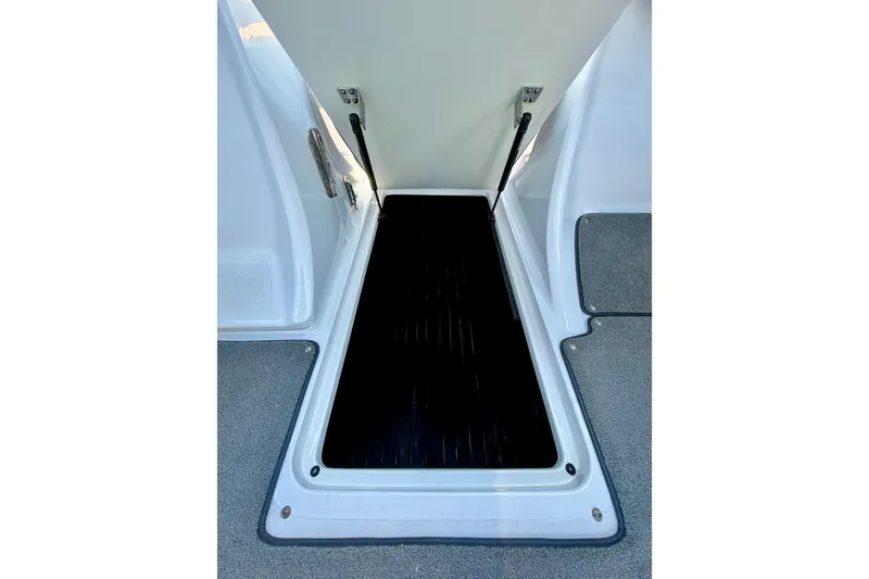Slide: The Image of Open storage compartment on 2013 Cobalt 262 boat, featuring black interior and white exterior. - 37