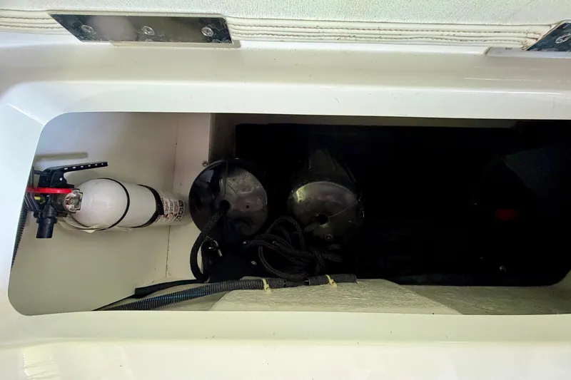 Slide: The Image of Storage compartment in a 2013 Cobalt 262 boat with fire extinguisher and equipment. - 40