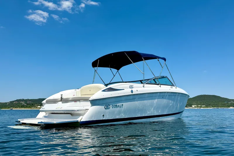 Slide: The Image of 2013 Cobalt 262 boat on calm water under clear blue sky. - 7