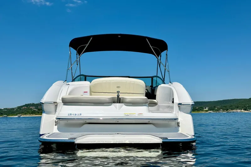 Slide: The Image of 2013 Cobalt 262 boat on water, rear view with canopy, clear sky background. - 8