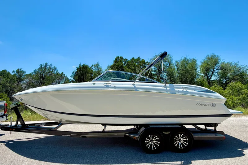 Slide: The Image of 2013 Cobalt 262 boat on trailer, parked outdoors under clear blue sky. - 9