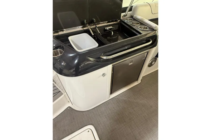 Slide: The Image of 2016 Formula 350 Crossover Bowrider kitchenette with sink, fridge, and cup holders. - 25