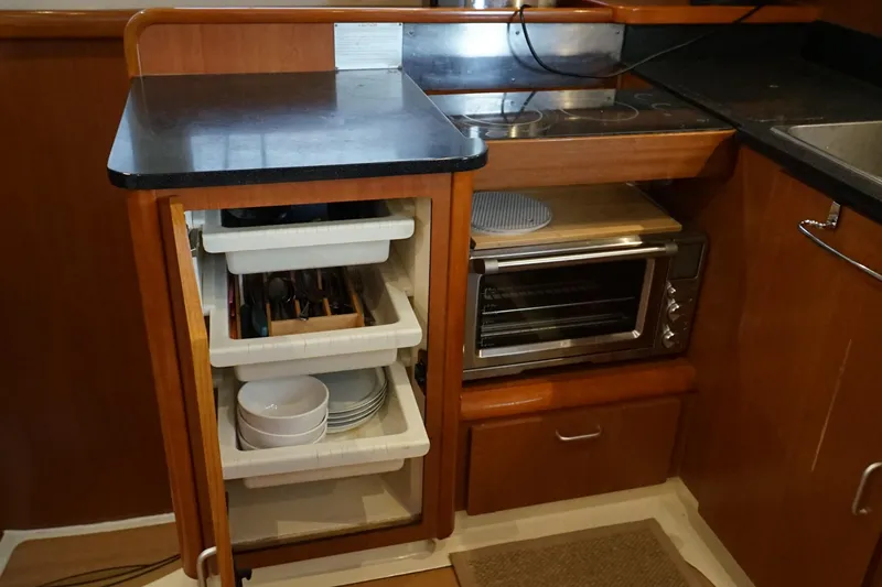 Slide: The Image of Compact kitchen area in a 2007 Leopard 46 yacht with storage and appliances. - 11