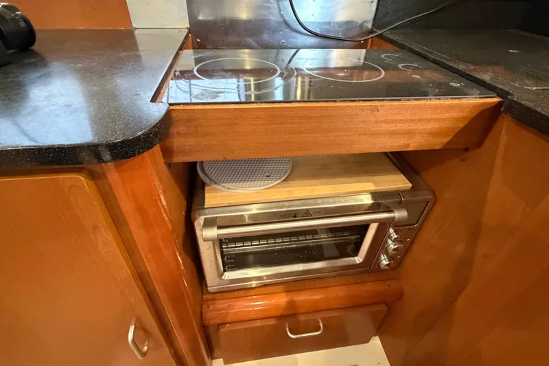 Slide: The Image of Compact kitchen area in a 2007 Leopard 46 yacht with stove and toaster oven. - 12