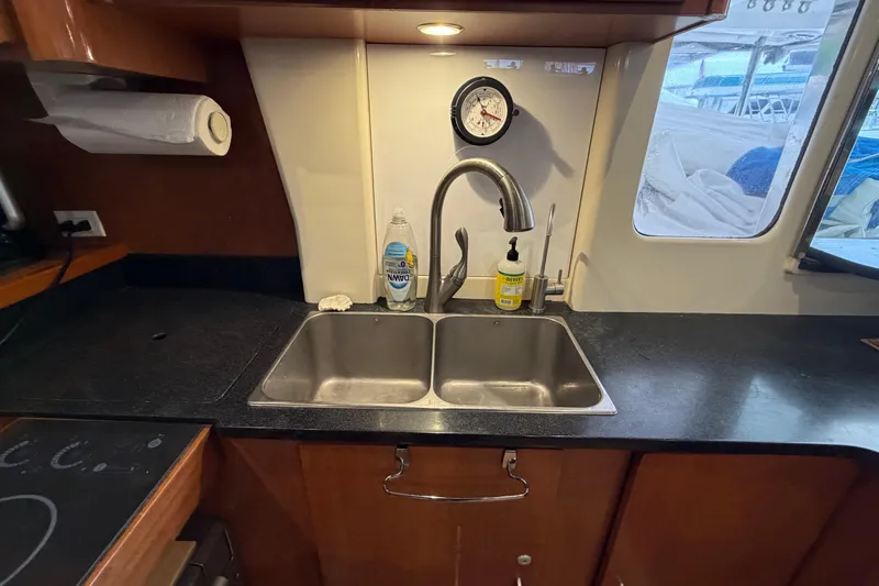 Slide: The Image of Kitchen sink area in a 2007 Leopard 46 yacht with countertop and window view. - 14