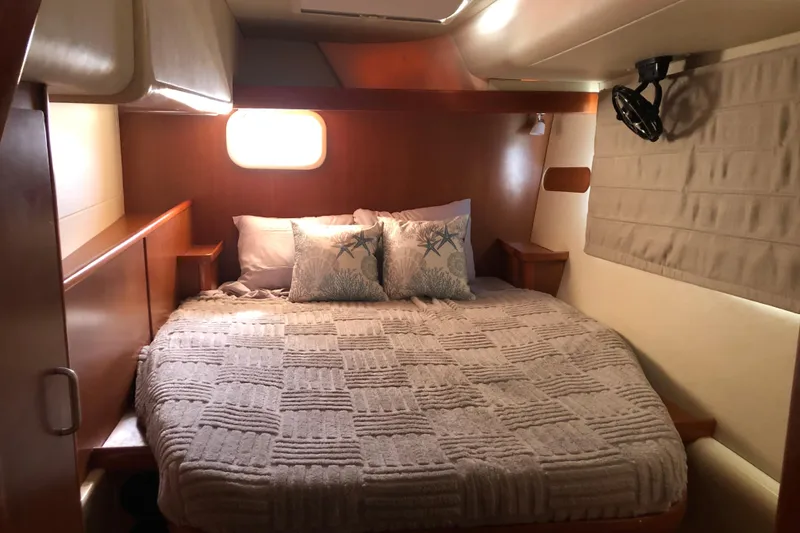 Slide: The Image of Cozy bedroom interior of 2007 Leopard 46 yacht with plush bedding and wooden accents. - 17