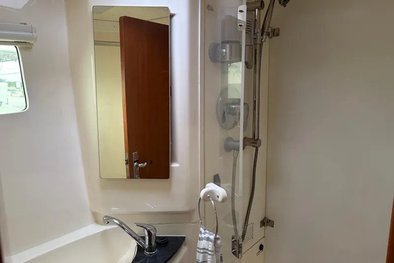 Slide: The Image of Bathroom interior of a 2007 Leopard 46 yacht, featuring a sink, mirror, and shower. - 22
