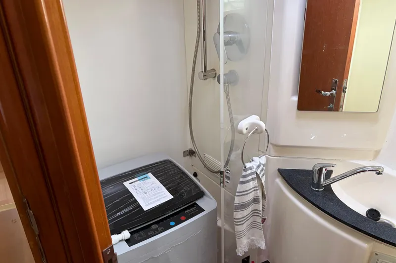 Slide: The Image of Compact bathroom with shower, sink, and washing machine in a 2007 Leopard 46 yacht. - 24
