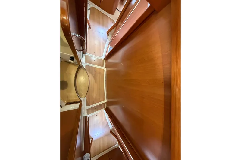 Slide: The Image of Interior view of a 2007 Leopard 46 yacht, featuring wooden cabinetry and flooring. - 25