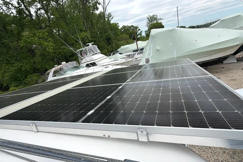 Slide: The Image of Solar panels on a 2007 Leopard 46 yacht, surrounded by covered boats and trees. - 36