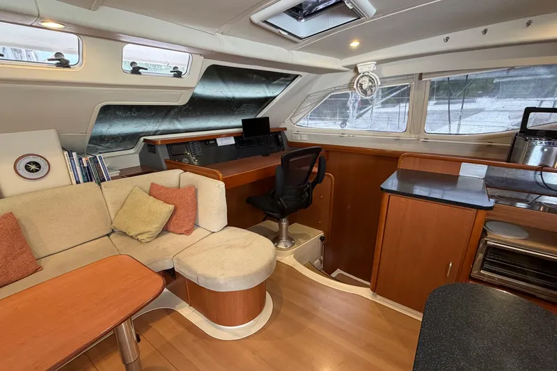 Slide: The Image of Interior of a 2007 Leopard 46 yacht featuring a cozy seating area and navigation station. - 6