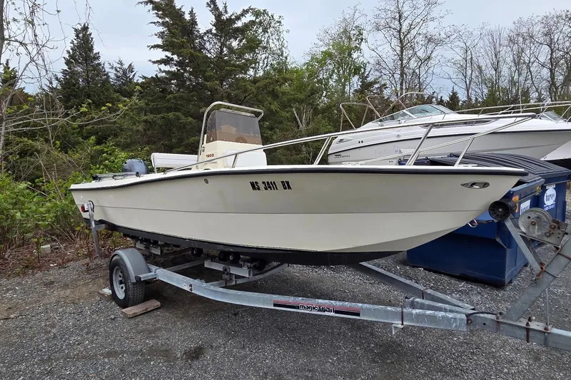 The Image of 1995 Sportsman Island Reef 19 Center Console boat on trailer, parked outdoors. - 1