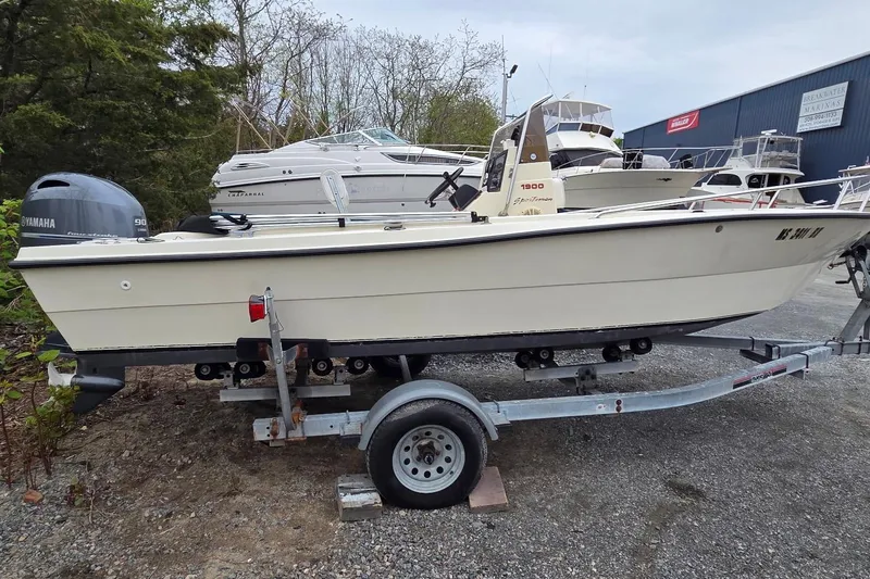 Slide: The Image of 1995 Sportsman Island Reef 19 Center Console boat on trailer, parked outdoors. - 7