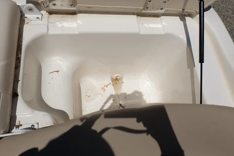 Slide: The Image of 2006 Glastron GXL 205 boat storage compartment, open and empty, with visible shadows. - 20
