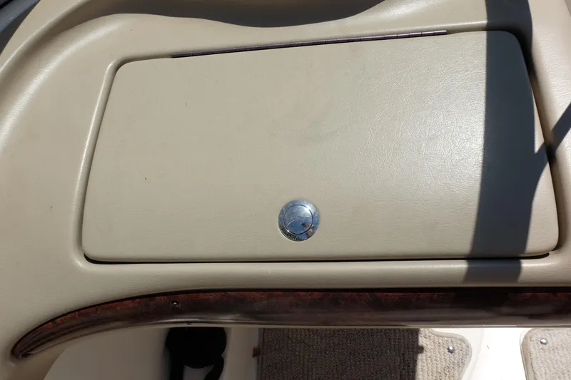 Slide: The Image of 2006 Glastron GXL 205 boat dashboard compartment with beige cover and chrome handle. - 26