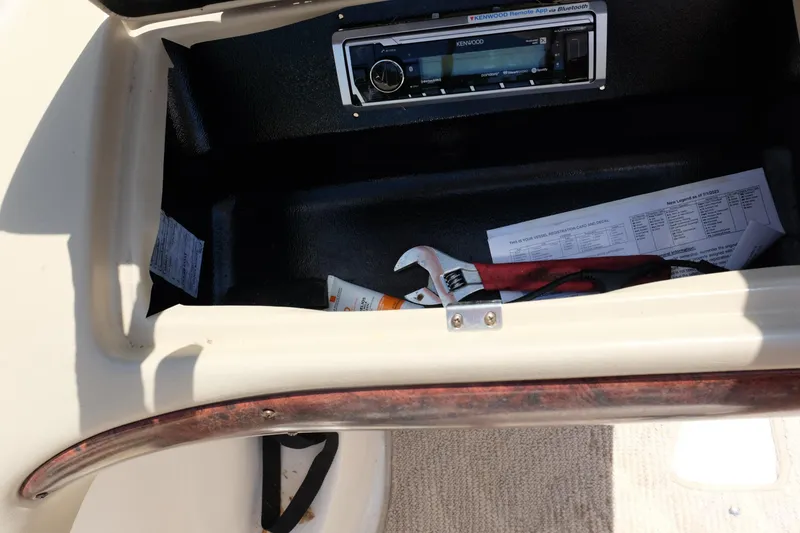 Slide: The Image of Glove compartment of 2006 Glastron GXL 205 with tools and Kenwood stereo. - 27