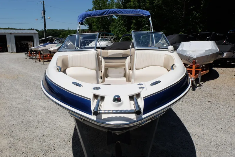 Slide: The Image of 2006 Glastron GXL 205 boat with blue and white interior, parked outdoors. - 3