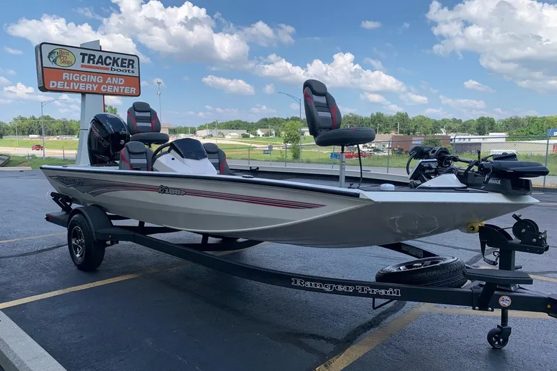 Slide: The Image of 2026 Ranger RT188P boat on trailer at Tracker Boats center, under blue sky. - 2