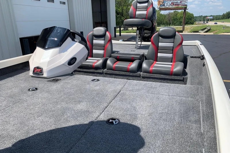 Slide: The Image of 2026 Ranger RT188P boat interior with gray and red seating, parked outdoors. - 8